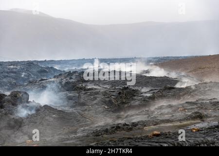 Vista ravvicinata della crosta di lava crosta o della roccia ingegnosa e del vapore, raffreddata dall'eruzione del 2021 del vulcano Mt. Fagradersfjall nella valle di Geldingadalir Foto Stock