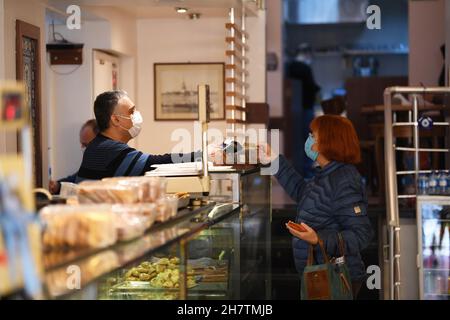 Istanbul, Turchia. 22 novembre 2021. Un cliente paga alla Lebon Patisserie di Istanbul, Turchia, 22 novembre 2021. PER ANDARE CON 'Feature: Turks difendere Istanbul storica patisserie dalla chiusura in mezzo COVID-19' Credit: Sadat/Xinhua/Alamy Live News Foto Stock