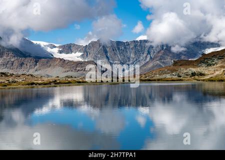 Vista panoramica sull'acqua del Riffelsee vicino Zermatt, Svizzera verso il massiccio del Monte Rosa nella parte orientale delle Alpi Pennine, a nord di t Foto Stock