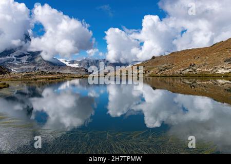 Vista panoramica sull'acqua del Riffelsee vicino Zermatt, Svizzera verso il massiccio del Monte Rosa nella parte orientale delle Alpi Pennine, a nord di t Foto Stock