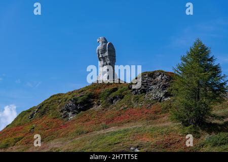 Passo del Sempione, Svizzera-ottobre 2021; vista ad angolo basso del monumento in pietra raffigurante un'aquila, simbolo dell'XI Brigata Alpina svizzera sul monte alto Foto Stock