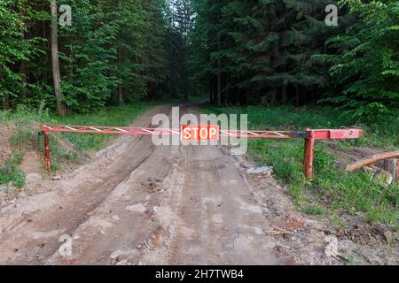 Segnale di stop su una strada forestale. Barriera chiusa. L'entrata nella foresta è proibita. Foto Stock
