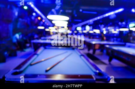 Sfondo sfocato della sala giochi biliardo - composizione sfocata del salone del gioco in piscina con toni di colore blu dominante e luce al neon incandescente Foto Stock