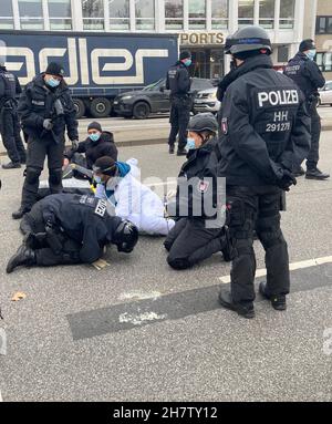 Amburgo, Germania. 25 Nov 2021. Gli attivisti della ribellione di estinzione protestano ad Amburgo. Un attivista ha bloccato le mani sulla strada. L'azione all'importante incrocio di Schlump ha causato ingorghi. Credit: Thomas Müller/dpa/Alamy Live News Foto Stock
