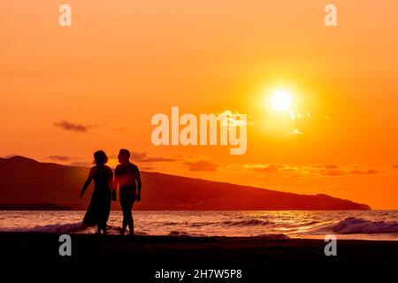 Silhouette di due persone al tramonto, amore e ballo, divertirsi. Foto Stock