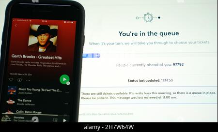 Un portatile che mostra la pagina di prenotazione Ticketmaster per i prossimi concerti Garth Brooks al Croke Park di Dublino, accanto a un telefono che suona i suoi migliori successi su Spotify. Garth Brooks suonerà cinque concerti a Dublino l'anno prossimo, dopo che altre tre date sono state aggiunte a causa della domanda dalla sua base di fan irlandesi. Data foto: Mercoledì 25 agosto 2021. Foto Stock