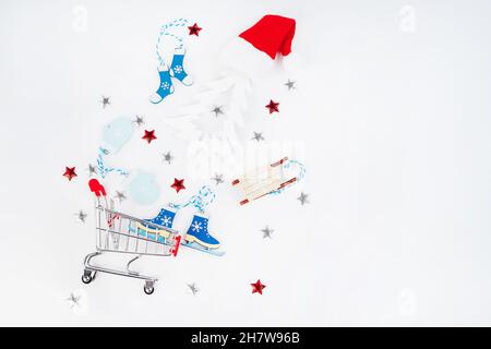 Composizione di Natale. Natale e Capodanno background.Trolley da un supermercato con regali di Capodanno e giocattoli di Capodanno su uno sfondo chiaro Foto Stock