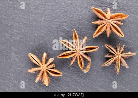 Molte delle stelle secche e fragranti anice su una pietra ardesia, da vicino, vista dall'alto. Foto Stock