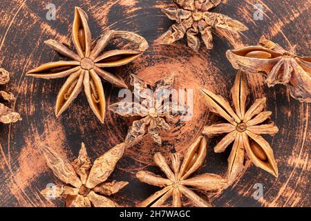 Diverse stelle di anice stellato secco fragrante su un piatto di argilla, primo piano, vista dall'alto. Foto Stock