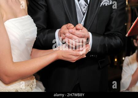 Primo piano di vista delle mani dello sposo che depositano soldi seri nelle mani della sposa durante il suo matrimonio. Foto Stock