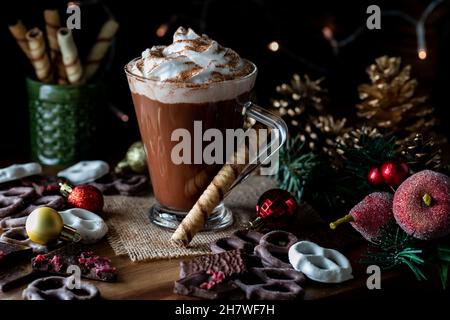 Una tazza di cioccolata calda con panna a frusta e polvere di cacao cosparsi sulla parte superiore. Foto Stock