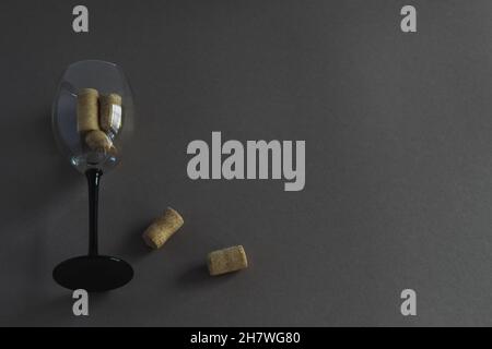 Bicchiere di vino con tappi di vino su sfondo scuro con spazio per il testo. Foto Stock
