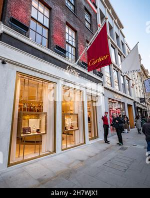 Cartier, Bond Street, Londra. Gli amanti dello shopping camminano vicino all'entrata del negozio di gioielli Cartier nel ricco quartiere dello shopping di Londra. Foto Stock