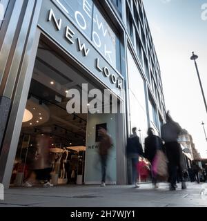 Negozio di moda New Look, Oxford Street, Londra. Gli amanti dello shopping passano l'entrata al negozio di moda di High Street nel trafficato quartiere dello shopping di Londra. Foto Stock