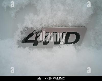 Abbreviazione 4wd - trazione integrale - su una vettura bianca nella neve nella parte posteriore in inverno. Foto Stock