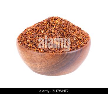 Tè rosso Rooibos in ciotola di legno, isolato su sfondo bianco. Tè tradizionale alle erbe e biologico. Foto Stock