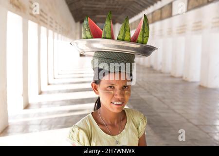 Myanmar, Nyaung-U ragazza che vende cocomero all'interno del corridoio della Pagoda di Shwezigon. Foto Stock