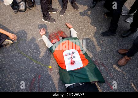 25 novembre 2021, Dhaka, Bangladesh: Uno studente giace sulla strada fingendo di essere vittima di un incidente stradale.. Studenti del Notre Dame College ha organizzato una dimostrazione chiedendo giustizia per il loro ucciso collega Nayeem Hassan e strade sicure. Nayeem è stato ucciso in un incidente stradale il 25 novembre. L'incidente è stato causato da un camion di dump della Dhaka South City Corporation. Gli studenti hanno organizzato per la prima volta una dimostrazione presso il luogo dell'incidente e successivamente si sono trasferiti al Dhaka South City Corporation Building chiedendo di vedere il Sindaco. (Credit Image: © Rizwan/Pacific Press via ZUMA Press Wire) Foto Stock