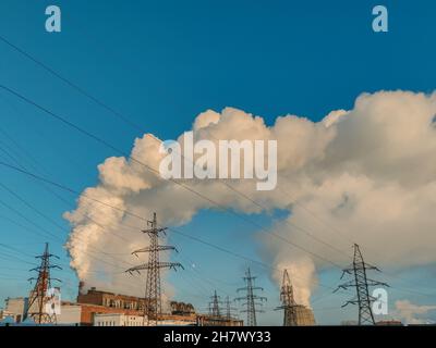 Emissioni di camino dalle centrali elettriche industriali di lignite. Enormi nubi di fumo da camini, tubi di una centrale termica, inquinando l'atmosfera Foto Stock