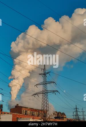 Enormi nubi di fumo da camini, tubi di una centrale termica, inquinando l'atmosfera inquinamento atmosferico da camini di centrale. Emissione di camino Foto Stock