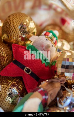 Decorazioni natalizie con sfera dorata scintillante sullo sfondo. Elfo stella di Natale sulla parte anteriore. Verticale Foto Stock