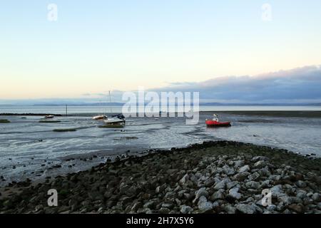 Autunnale vista in prima serata di barche ormeggiate su fango e attraverso Morecambe Bay al Lake District da Marine Road East, Morecambe, Lancashire, E. Foto Stock