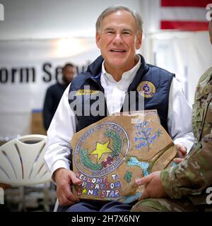 Del Rio, Stati Uniti. 24 novembre 2021. Texas Gov. Greg Abbott ha ricevuto un regalo da parte dei membri del Dipartimento militare del Texas e del Dipartimento di pubblica sicurezza del Texas durante una celebrazione del Ringraziamento del 24 novembre 2021 a del Rio, Texas. Credit: Capt. Phil Fountain/DOD/Alamy Live News Foto Stock