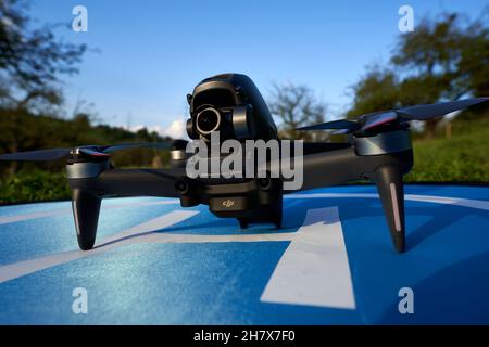 Nürtingen, Germania - 26 giugno 2021: Drone DJI fpv su una piattaforma di lancio blu. Alberi e prato sullo sfondo. Vista frontale. Foto Stock