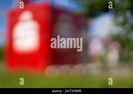 Donzdorf, Germania - 23 maggio 2021: Punto SB-Service offuscato dalla banca (Sparkasse). Edificio rosso a forma di cubo con bandiera è utilizzato per prelevare contanti e. Foto Stock