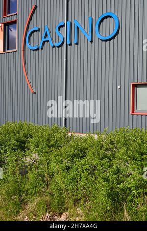 Donzdorf, Germania - 23 maggio 2021: Lettere blu casinò aristo su un edificio grigio con 3 finestre sulla facciata. Cespugli verdi in primo piano. Vista da Foto Stock