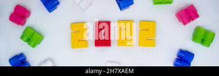 Banner colorati blocchi da costruzione, giocattoli plastica figura su sfondo bianco. Foto Stock