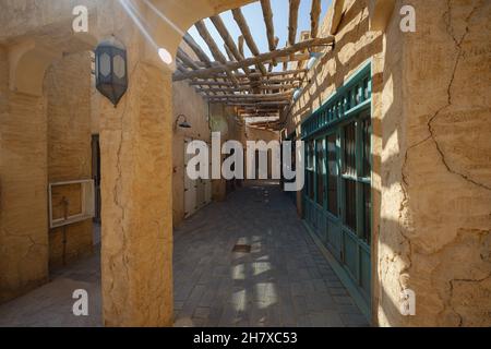 Dubai, Emirati Arabi Uniti 17 Febbraio 2020: Edifici antichi di Dubai e la strada Araba. Quartiere storico di al Fahidi, al Bastakiya. Distretto del Patrimonio negli Emirati Arabi Uniti. Fresco ombra sulle strade della città a mezzogiorno Foto Stock