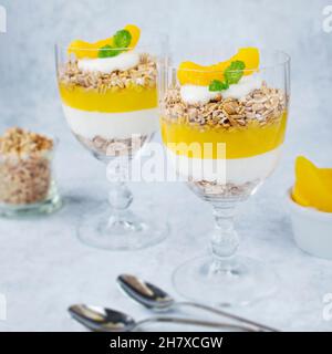 Un dolce sano con mousse di pesca, formaggio naturale e avena espansa. Foto Stock