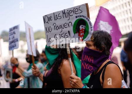 Caracas, Venezuela. 25 Nov 2021. "Le donne non dovrebbero dover salvare la crisi!” Si legge la targhetta di un attivista accoccolato che partecipa a un raduno nella Giornata Internazionale per l'eliminazione della violenza contro le donne. Credit: Jesus Vargas/dpa/Alamy Live News Foto Stock