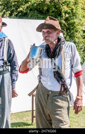 Ricostruzione dell'epoca dei "cowboy" del selvaggio West negli Stati Uniti. American West Enactment. Haggard volto del veterano americano bianco, attore, bevente Foto Stock