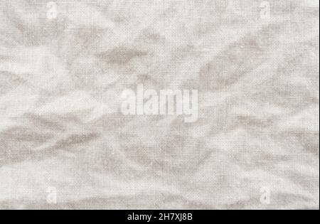 Un pezzo di tessuto sgualcito dalle onde grigie e si piega. Materiale da cucire. Sfondo bianco in tela con delicato motivo a righe senza cuciture Foto Stock