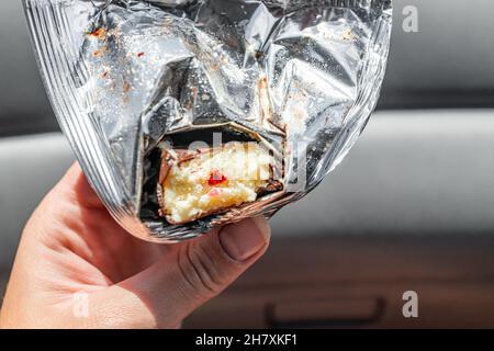 Storebuched russo cheesecake gelato torta al formaggio bar aperto con ripieno glassato rivestito di cacao confezionato foglio in mano dalla Russia mangiare Foto Stock