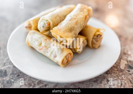 Primo piano di involtini di uova di primavera fritte su piatto bianco macro primo piano in ristorante cinese asiatico o a casa come antipasto per la cena Foto Stock