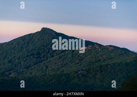 Sugar Mountain stazione sciistica città tramonto scuro tramonto vista crepuscolo in North Carolina Blue Ridge Appalachian montagne con silhouette di cresta di picco e luce del sole su Foto Stock