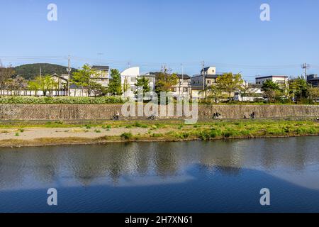 Kyoto, Giappone acqua del fiume Kamo in tramonto di sera con il paesaggio urbano delle case degli edifici sulla riva del canale in primavera Foto Stock