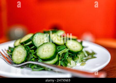 Tradizionale Giappone interno rosso alcova colore sfondo bokeh casa o ristorante ryokan con insalata verde piatto vicino al cetriolo giapponese Foto Stock