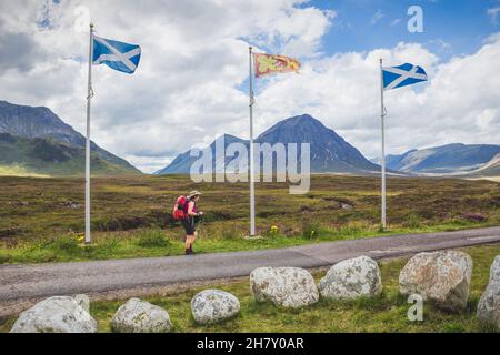 Scozia, Glencoe - ago 2021: Viaggio donna backpacking su strada viaggio in natura paesaggio stupefacente. Scozia, Glencoe, avventura estiva. Foto Stock