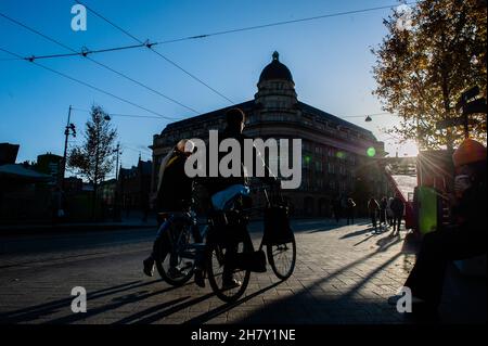 Amsterdam, Paesi Bassi. 25 Nov 2021. Le persone hanno visto con le loro biciclette durante il tramonto a Kavelstraat prima del Black Friday con il centro commerciale che guarda più vuoto rispetto ad altri anni. Credit: SOPA Images Limited/Alamy Live News Foto Stock