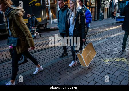 Amsterdam, Paesi Bassi. 25 Nov 2021. Le persone che trasportano qualche borsa per lo shopping, a Kavelstraat prima del Black Friday con il centro commerciale che guarda più vuoto rispetto ad altri anni. Credit: SOPA Images Limited/Alamy Live News Foto Stock