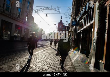 Amsterdam, Paesi Bassi. 25 Nov 2021. Le persone passeggiano davanti ai negozi durante il tramonto a Kavelstraat, prima del Black Friday, con il centro commerciale che guarda più vuoto rispetto agli altri anni. Credit: SOPA Images Limited/Alamy Live News Foto Stock