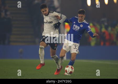 Leicester, Regno Unito. 25 Nov 2021. Legia Warsaw Forward Ernest Mui (20) combatte per la palla con il difensore di Leicester City Luke Thomas (33) durante la partita di gruppo UEFA Europa League tra Leicester City e Legia Warsaw al King Power Stadium di Leicester, Inghilterra, il 25 novembre 2021. Foto di Jurek Biegus. Solo per uso editoriale, licenza richiesta per uso commerciale. Nessun utilizzo nelle scommesse, nei giochi o nelle pubblicazioni di un singolo club/campionato/giocatore. Credit: UK Sports Pics Ltd/Alamy Live News Foto Stock