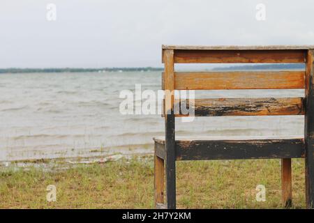 Dietro la panchina vuota accanto al lago nel parco. Foto Stock