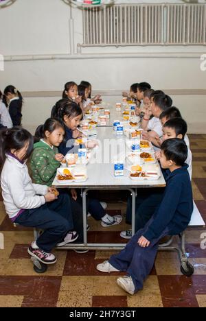 St. Paul, Minnesota. Scuola charter per l'Hmong. Gli studenti di Hmong di 2° e 3° grado mangiano il pranzo nella caffetteria della scuola. Foto Stock