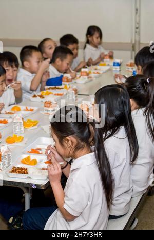 St. Paul, Minnesota. Scuola charter per l'Hmong. Gli studenti di Hmong di 2° e 3° grado mangiano il pranzo nella caffetteria della scuola. Foto Stock