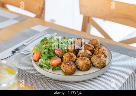 Polpette di verdure vegane sul piatto con insalata fresca su tavolo da cucina in legno. Pranzo vegetariano. Pianta cibo basato. Concetto di cibo sano. Selettivo per Foto Stock
